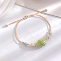 Detail of adjustable beach bracelet featuring ceramic seashell and starfish charms - Light Green