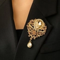 Vintage gouden bloemenbroche met champagne kristallen hanger op een zwarte blazer revers - Imitatie Goud (01 0518)