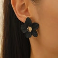 Boucles d'oreilles fleurs noir mat avec centre doré portées par un mannequin - Boucles d'oreilles puces pétale noir (Cœur de fleur large en or KC S19)