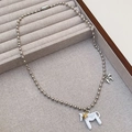 Detailansicht einer silbernen Kugelkette mit weißem Emaille Pony-Anhänger und Goldstern - Weißer Kugelkette Stil