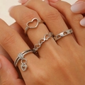 Detail of four silver-colored heart-shaped rings featuring hollow designs and a charm pendant - Hollow Heart Set (01 White KS81)