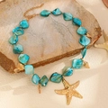 Dettaglio macro della collana oceanica con stelle marine dorate e perline turchesi - Collana di Pietre Blu (5184)