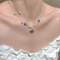 Detail of layered ocean-style necklace featuring silver scallop pendant and blue beads - Bright Silver Beaded Style (A-980)