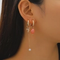 Asymmetric gold earrings with hummingbird charm and pearl drop on female model - Hummingbird Orange Stone Style (10680)