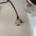 Primer plano del colgante de gota de plata pulida en un collar largo de cordón negro sobrio - Cobre / Estilo Abanico Espejo