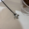 Primer plano de un colgante de estrella plateada con centro hueco en collar de cordón - Cobre / Estilo Estrella Hueca
