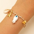 Detailed close-up of woven marine bracelet with starfish, shell, and evil eye charms - White Woven Starfish (18 White 1610)