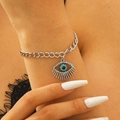 Detailed view of silver chain bracelet with crystal evil eye pendant on model's wrist - Bracelet / Silver