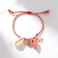 Handwoven red sea star bracelet featuring delicate shell and golden metal charms - Red