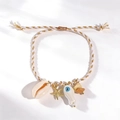 Handcrafted woven starfish bracelet with shell and blue evil eye charms in white and gold - White