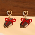 Detailed view of rugby ball earrings with red bow and heart-shaped crystal studs - Red Bow Football Rhinestone Earrings (12289)