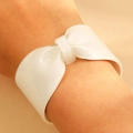 Macro detail of white glitter resin bow bracelet showing sparkling texture and wide open cuff - White