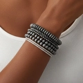 Close-up of stacked grey matte beaded bracelets with sparkling zirconia accents on a model - Gray And Bright Silver