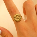 Macro shot of a golden sunflower ring with textured petals and floral design on finger - Sun Flower Shape / Gold (3919)