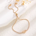 Detailed view of golden box chain bracelet with sparkling zircon heart pendant - Heart Pendant Style / Gold