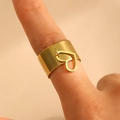 Macro shot of gold stainless steel wide ring with a delicate hanging heart pendant detail - Hollow Heart Style (G-530)