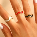 Three-piece set of wave-shaped 18k gold rings with red, white, and black enamel details - Wave Tricolor Enamel Set of 3