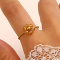 Makro-Detail eines böhmischen Kristallblumenrings mit vergoldetem, geflochtenem Band - Champagner