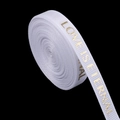 Detail of white ribbed ribbon with gold LOVE IS ETERNAL lettering and textured finish - 1cm Wide / White