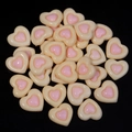 Macro detail of cream and pink heart resin charms for DIY phone cases and hair clips - Light Yellow