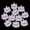 Macro detail of ten mini resin cat charms for DIY phone cases and hair accessories - 19x20mm / White Birthday Hat Puppy