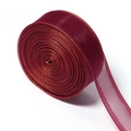Macro detail of wine red organza ribbon with shiny metallic edges for DIY crafts - Burgundy