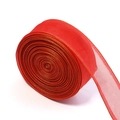 Macro detail of red sheer organza ribbon with gold metallic edge trim on a roll - Red