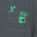 Adesivo murale panda luminoso con foglie di bambù che brilla su un interruttore al buio - Verde