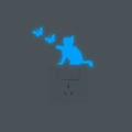 Adesivi murali gatto e farfalle luminosi blu accanto a un interruttore di luce - Blu
