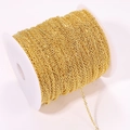 Macro-opname van gouden 304 roestvrijstalen kruisketting op een witte plastic spoel - 0.3 Diameter - 1m / 18K Goud