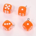 Detailed macro view of four translucent orange acrylic dice pendants with silver rings - Transparent Orange