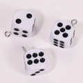 Close-up of white acrylic dice charms with black dots and silver eyelet pins for DIY jewelry - Opaque White
