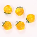 Detail of five translucent orange resin peach pendants with green leaves and metal rings - Transparent Orange