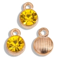 Detail of three rose gold birthstone charms with faceted yellow crystals and textured back - Gold Base Yellow
