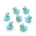 Macro shot of cute blue resin duck pendants with silver metal rings for DIY jewelry - Blue