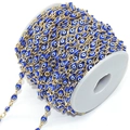 Detail of blue evil eye beads with golden copper chain on a white plastic spool - Royal Blue Eye KC Gold Chain