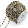 Detail of golden copper chain with black and white evil eye beads on a spool for DIY jewelry - Black Eye KC Gold Chain