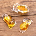 Set of 3 transparent resin pig charms with glowing yellow liquid and golden glitter inside - Orange