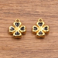 Goldener Kleeblatt-Anhänger mit schwarzer Emaille auf natürlichem Holzhintergrund - Schwarz