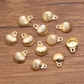 Golden alloy scallop shell charms for DIY jewelry making displayed on a wooden surface - Scallop Style (2)