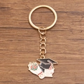Graduation keychain featuring mortarboard, diploma, and floral charms in gold finish - Style 7 (22X27mm)