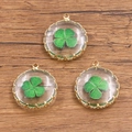 Trois pendentifs ronds en verre doré avec spécimens de fleurs séchées de trèfle à quatre feuilles - Trèfle de la Chance
