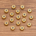 Goldene Edelstahl-Abstandshalter mit Silikonkern auf Holzoberfläche für Schmuck - 9x2mm / Gold
