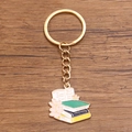 Enamel book stack keychain with golden chain and pink flower on a wooden background - Style 11 (28X28mm)