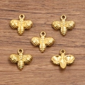 Five gold-plated stainless steel bee charms for jewelry making on a wooden background - 1609 Gold (Little Bee) / 11x11mm