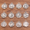 Detailed macro view of retro 12 zodiac constellation alloy pendants on a wooden surface - Antique Silver Set