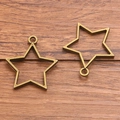 Antique bronze hollow star charm pendants for DIY jewelry making on wooden background - Pentagram