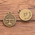 Vintage bronze Libra zodiac charm featuring Libra symbol and scales on wooden background - Antique Bronze - Libra