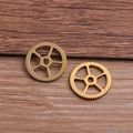 Dos dijes de engranajes steampunk dorados sobre madera para creación de joyas DIY - 1 Pieza / Oro antiguo