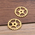 Macro shot of gold steampunk hollow gear charms for DIY jewelry on wooden surface - Antique Gold 1.6g